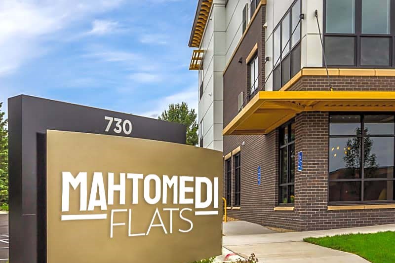 a sidewalk in front of a building with a sign that reads maintained flats