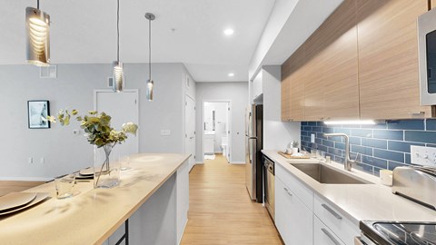 A modern kitchen with a long counter and a sink.