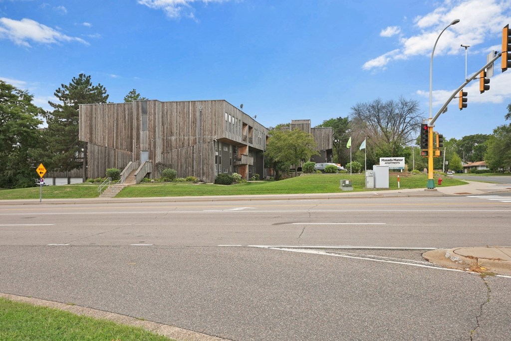 a wooden building on the corner of a street with an intersection