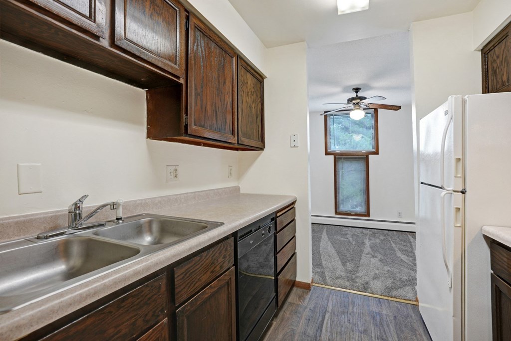 a kitchen with wooden cabinets and a sink and a refrigerator
