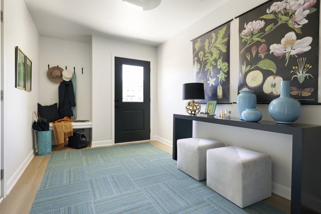 a living room with a blue rug and a black door