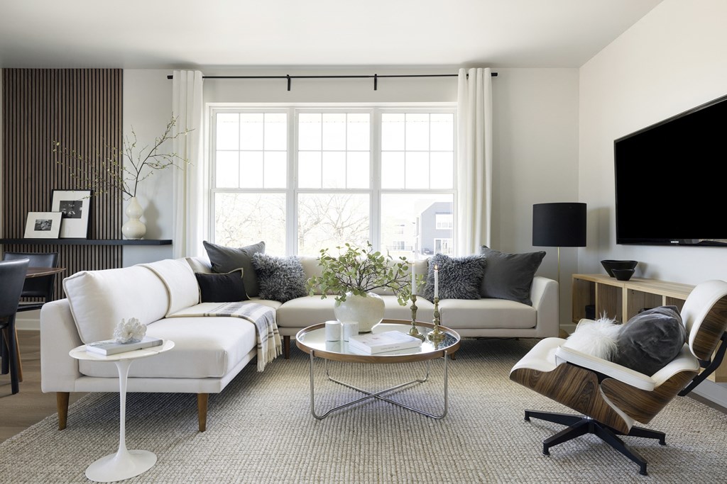 a living room with white furniture and a large window
