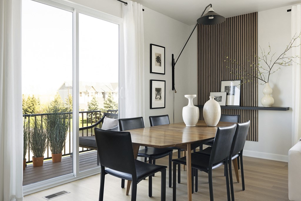 a dining room with a wooden table and black chairs