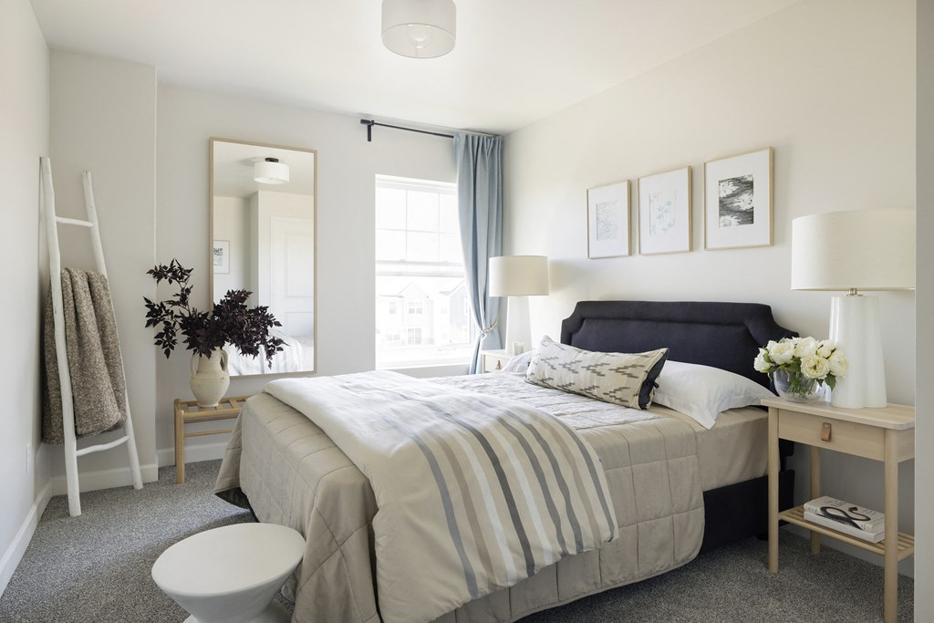 a bedroom with a bed and a mirror and a bathroom