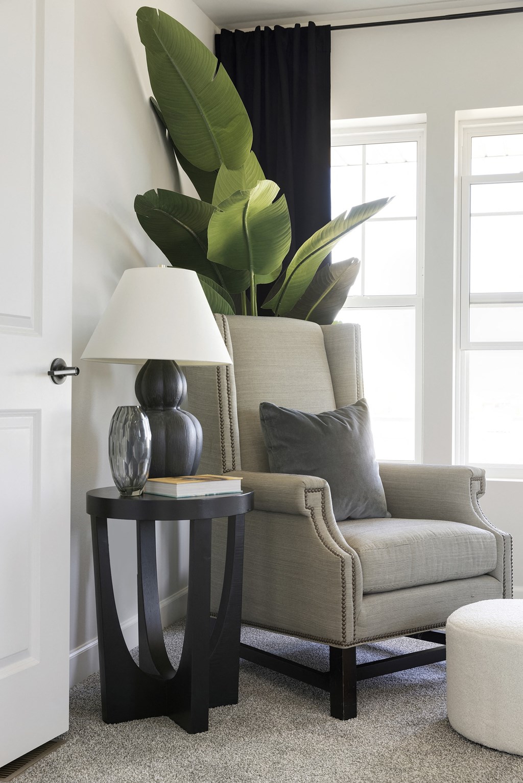 a living room with a chair and a lamp and a plant