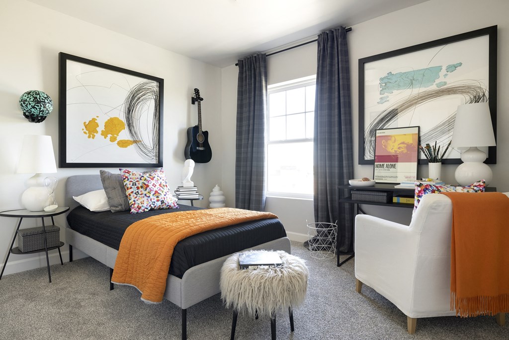 a bedroom with a bed and a chair and a desk