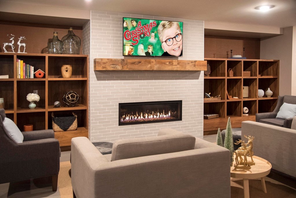 Community room with comfortable seating, tv and fireplace at The McMillan.