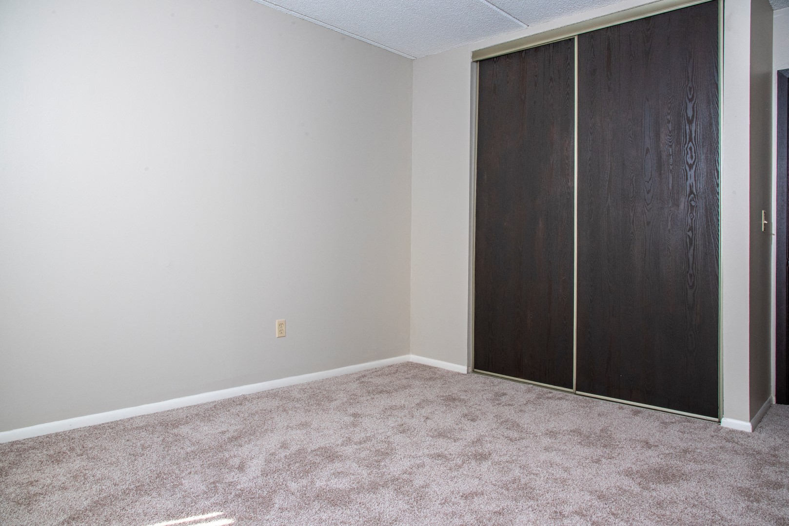 an empty room with a closet and carpet