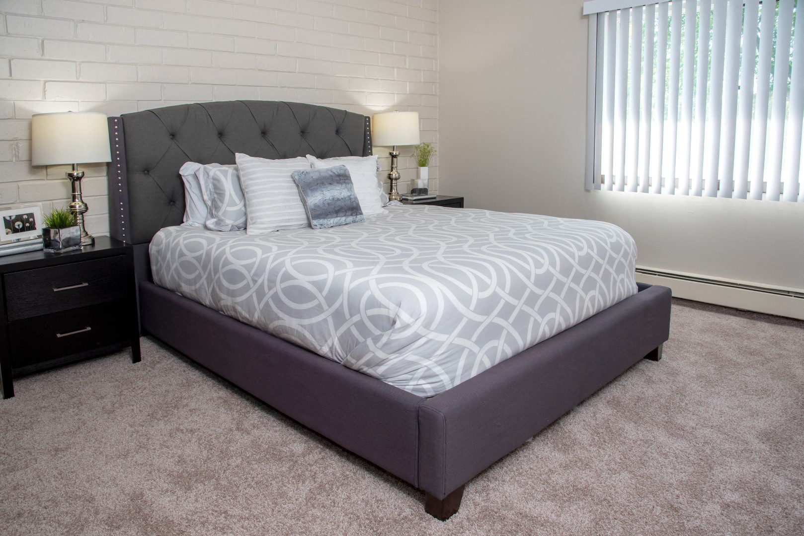 a bedroom with a large bed and a window with blinds