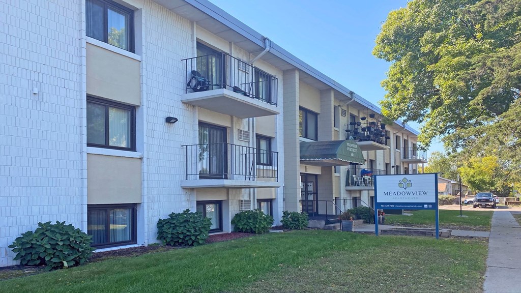 a white apartment building with a sign in front of it