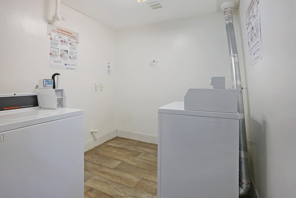 a laundry room with two washers and a microwave in it