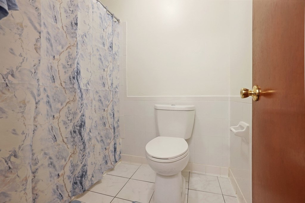 the bathroom has a marble shower and a toilet