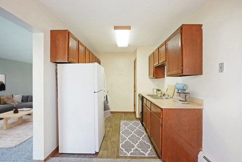 a small kitchen with a white refrigerator and wooden cabinets