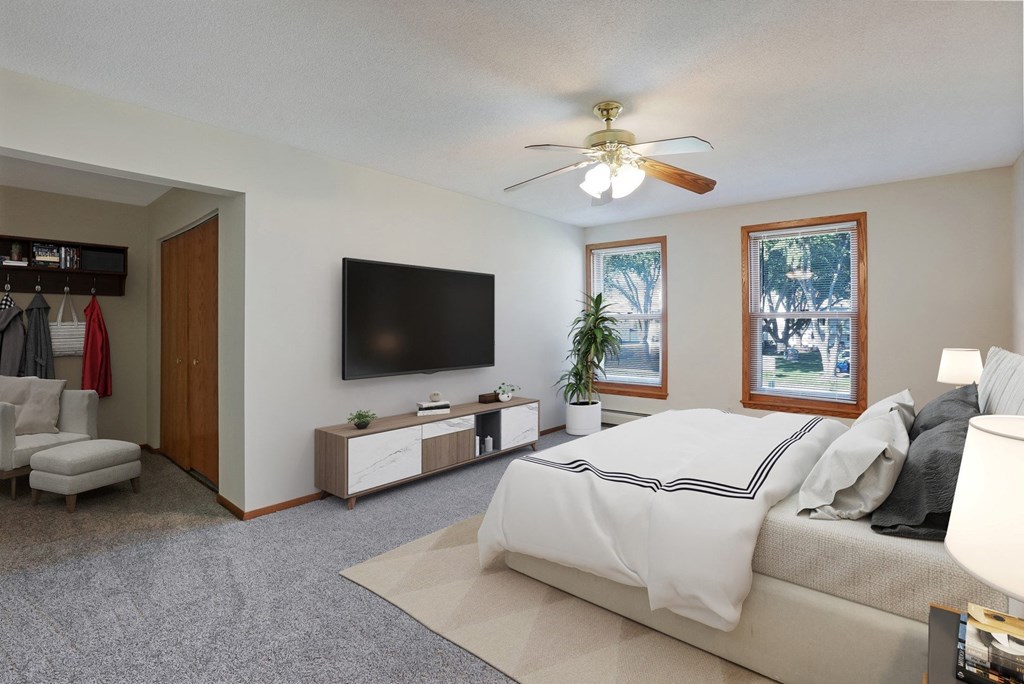 a bedroom with a large bed and a ceiling fan
