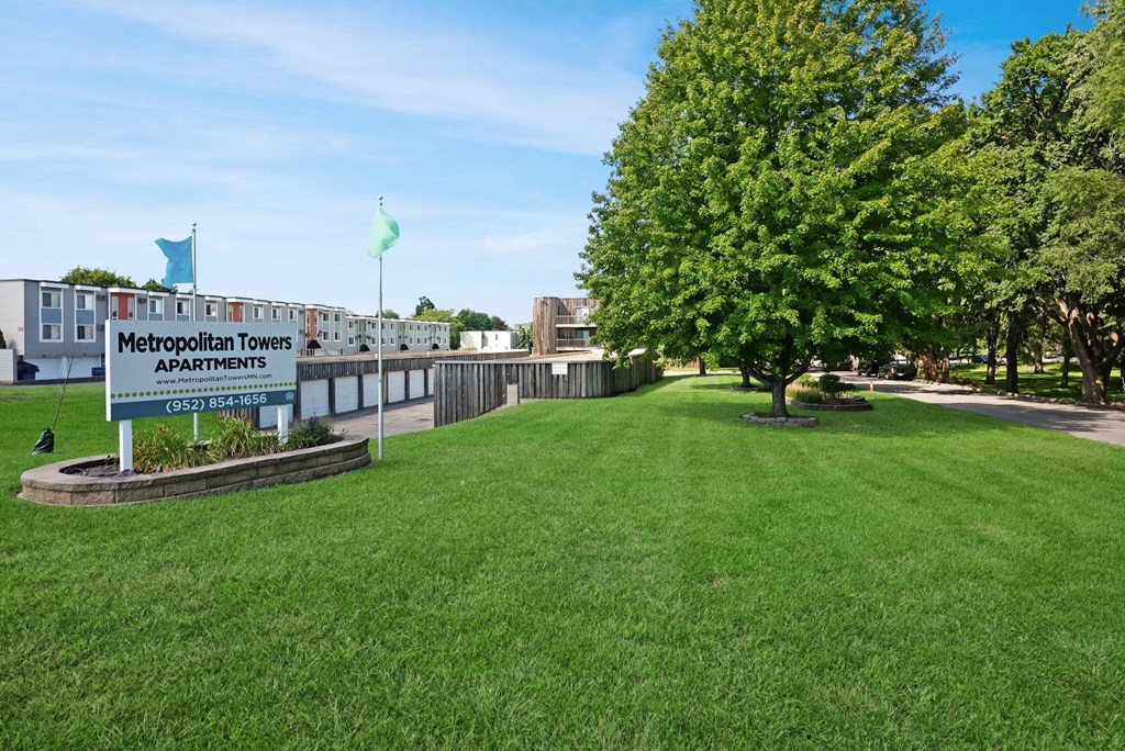a large lawn in front of a school with a sign