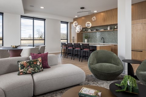 A modern living room with a grey sofa and a green armchair.