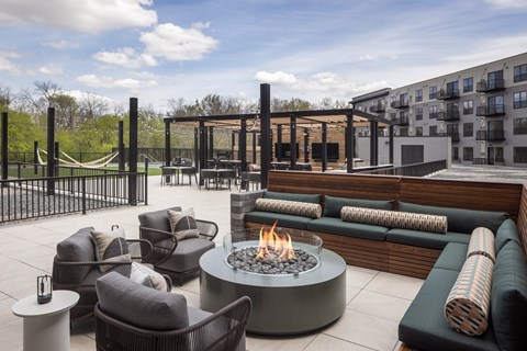 A patio with a fire pit and seating area.