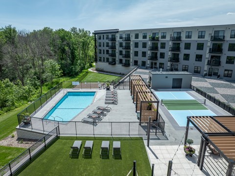 A large outdoor pool area with sun loungers and a wooden deck.