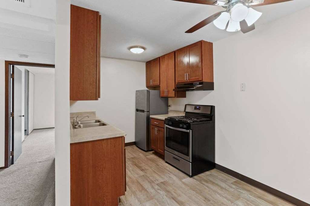 a kitchen with wooden cabinets and a ceiling fan