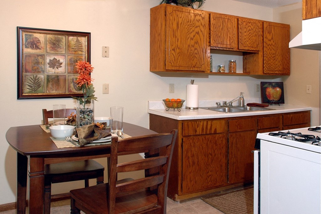 Kitchen with brown cabinets at Point of America Apartments, MN, 55443