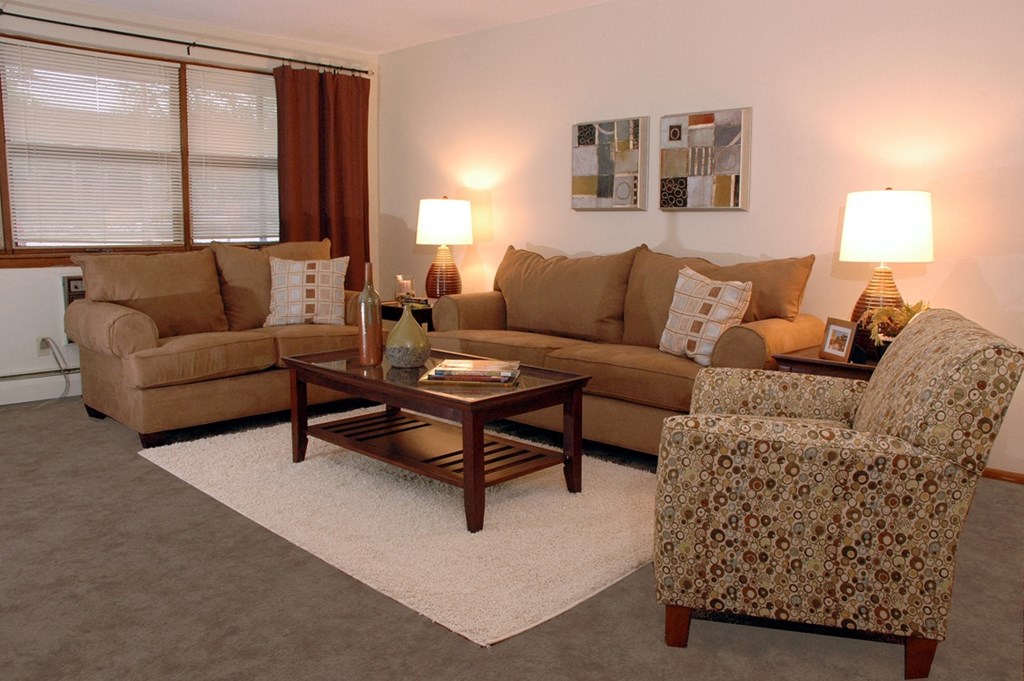a living room with a couch chair and coffee table at Point of America Apartments, Brooklyn Park, MN