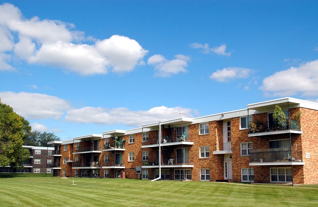 a grassy area in front of an apartment complex at Point of America Apartments,Minnesota, 55443