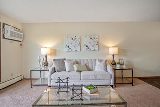 a living room with a white couch and a glass coffee table