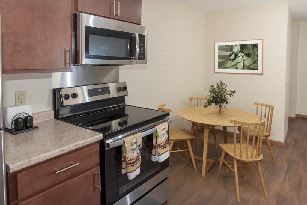 a kitchen with stainless steel appliances and a table with chairs