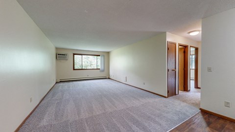 an empty living room with white walls and a carpeted floor