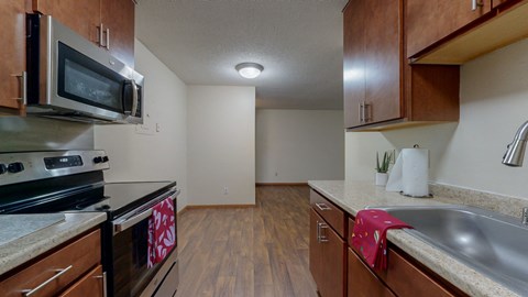 a kitchen with wood cabinets and stainless steel appliances