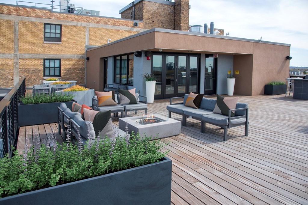 A patio with a table and chairs is surrounded by a brick wall.