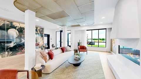 A modern living room with a white couch and a fireplace.