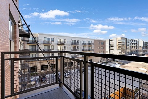 a balcony with a view of a city and a blue sky