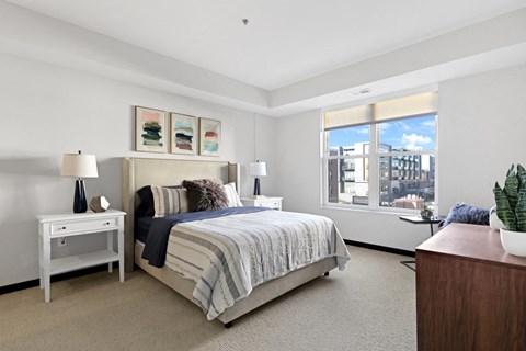 a bedroom with a bed and a large window