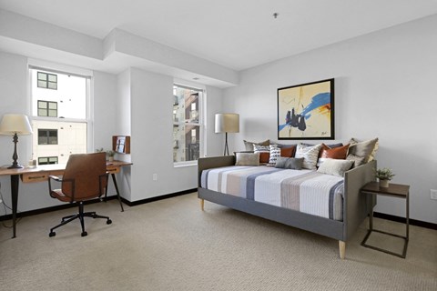 a bedroom with a bed and a desk with a chair