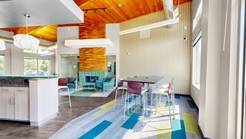 A modern kitchen with a wooden island and a dining table with chairs.