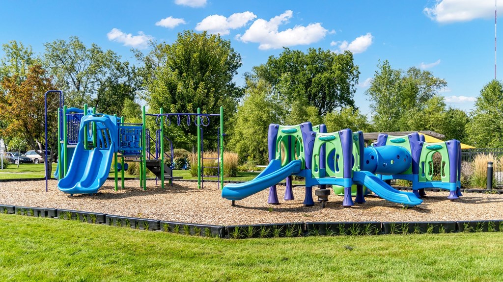A playground with a blue slide and purple climbing frame.
