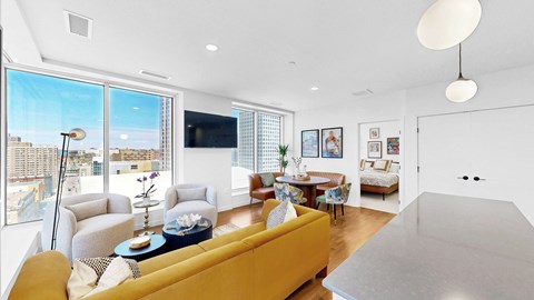 A living room with a yellow couch and a flat screen TV.