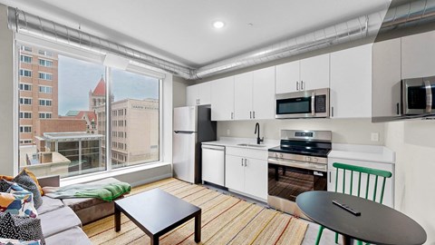 A kitchen with white cabinets and a black countertop.
