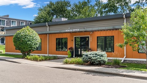 A rental office building with a green lawn in front.