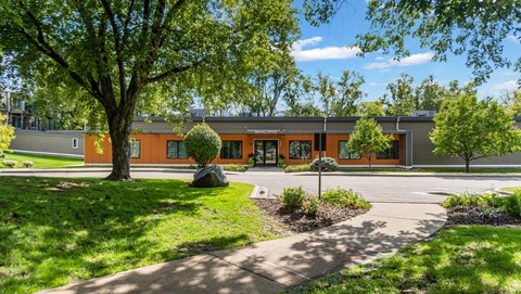 A building with orange walls and a green lawn in front.