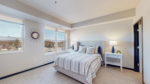 A bedroom with a large bed and a window overlooking a snowy landscape.