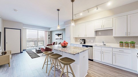 A kitchen with white cabinets and a marble countertop.