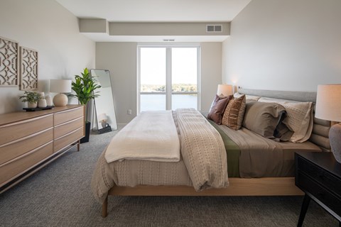 A bedroom with a large bed and a dresser with a mirror.