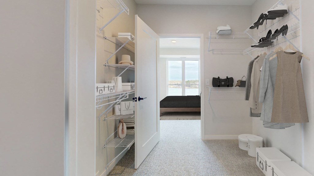 a walk in closet with a door open to a bedroom