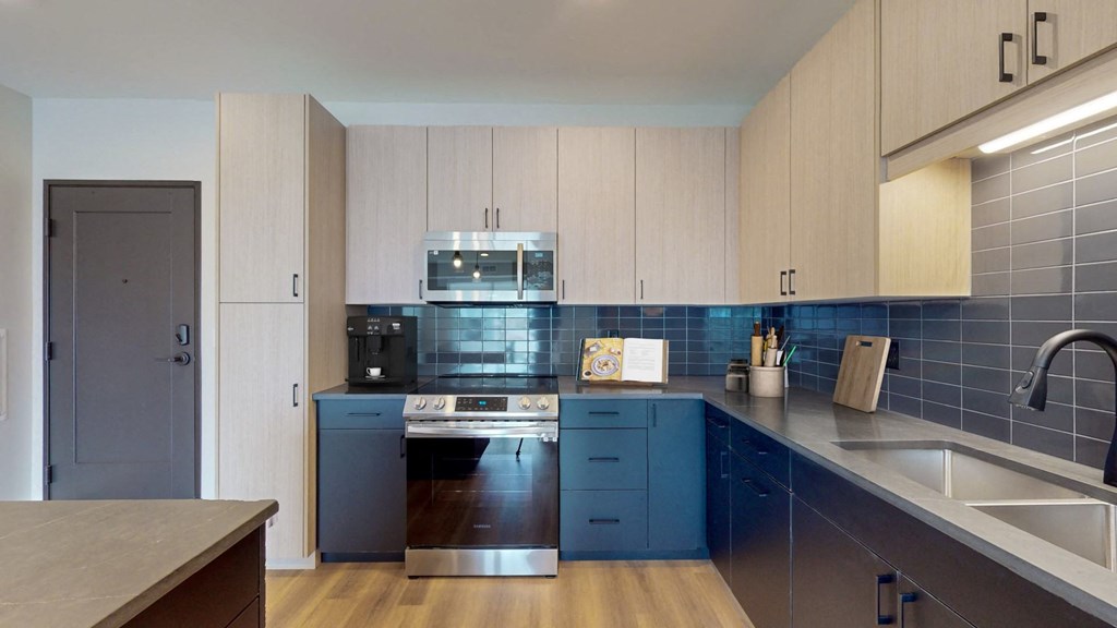 a kitchen with blue cabinets and stainless steel appliances