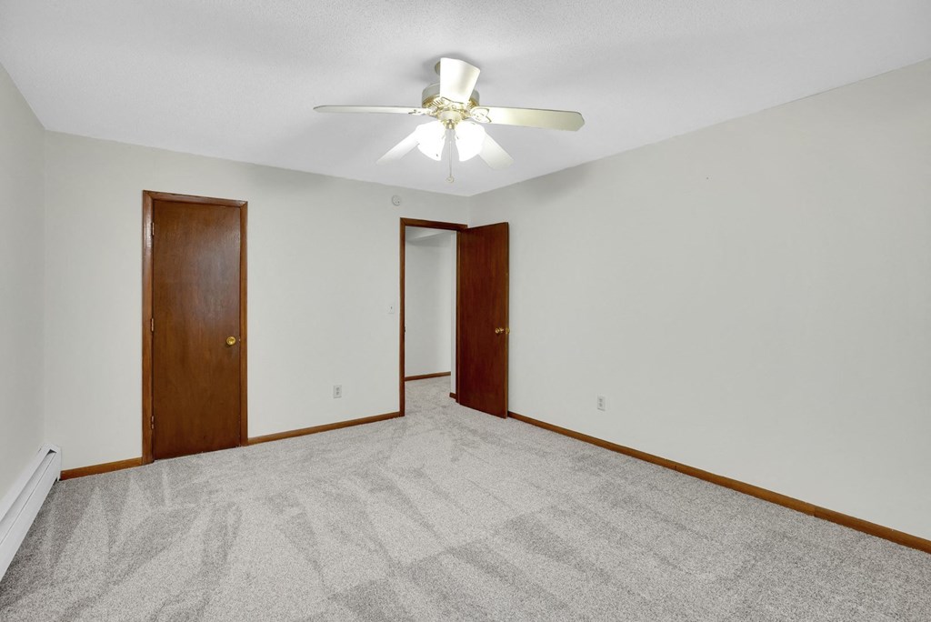 a empty room with a ceiling fan and a door