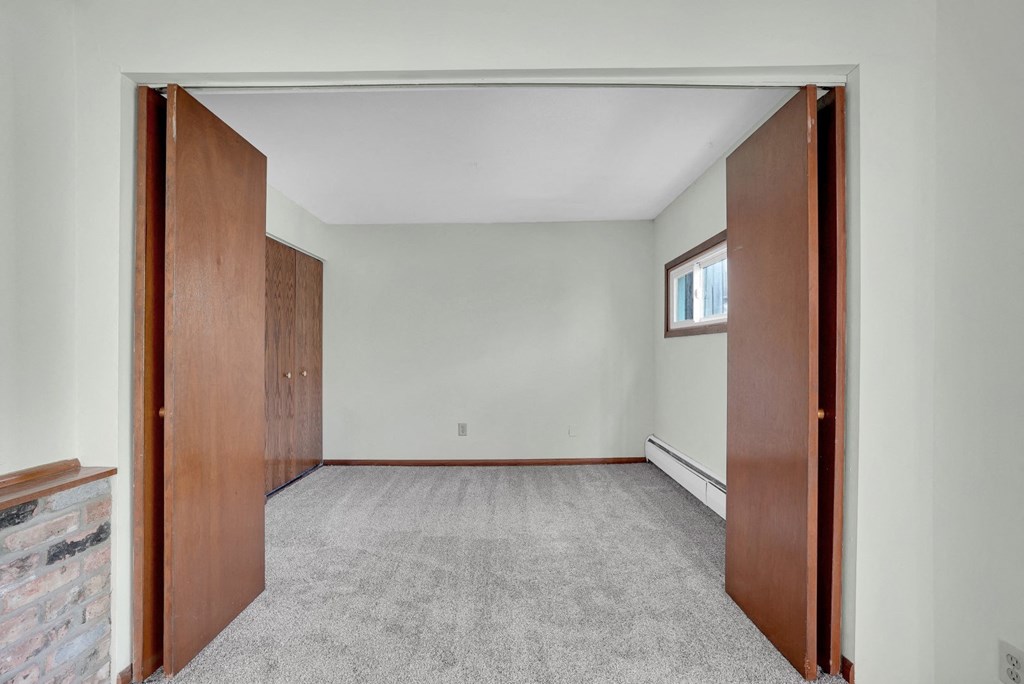 an empty living room with a door to a bedroom