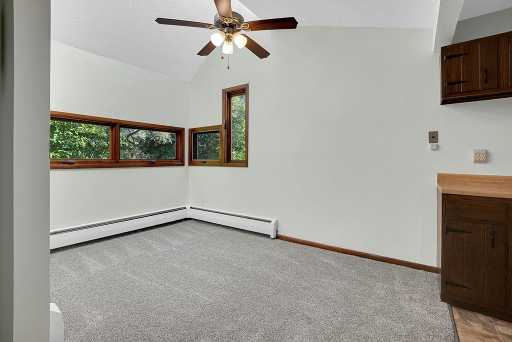 an empty living room with white walls and a ceiling fan