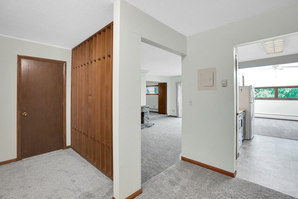 two views of a living room and a kitchen with a wooden door